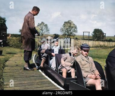 Holidaymakers on a miniature train in Seaford, East Sussex.  Two of the boys are wearing their school uniform. Stock Photo