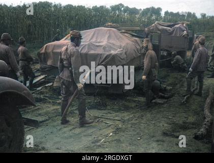 Japanese heavy trucks find progress slow in their advance through China, with planks used on muddy stretches Stock Photo