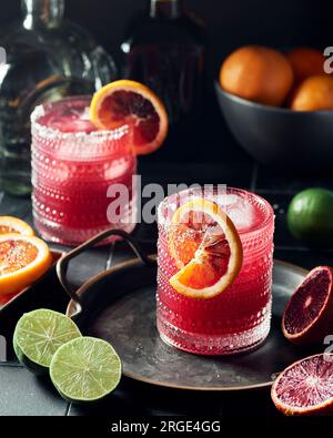 Two Glasses of Blood Orange Pomegranate Margaritas on a Dark Background Stock Photo