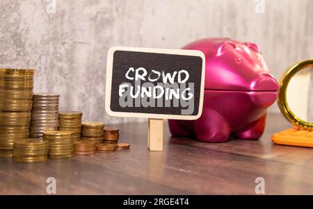 Crowdfunding concept. Handwriting red text in notepad on blue background, panorama, copy space Stock Photo