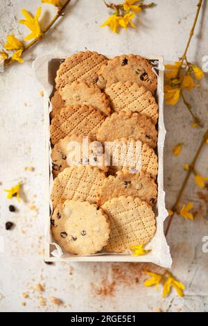 A box of Shrewsbury biscuits surrounded by yellow flowers Stock Photo