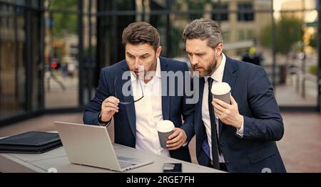 freelancer men have business online outdoor. freelancer men have business online with laptop. photo of freelancer men have business online. two freela Stock Photo