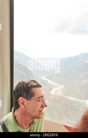 Senior hispanic man enjoying a cable car ride over the Chicamocha Canyon, in Santander, Colombia Stock Photo