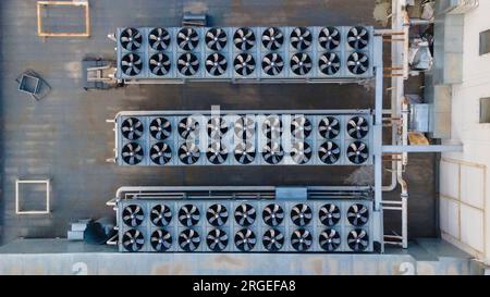 Three rows of fan coils on the roof of a building. Drone view Stock Photo