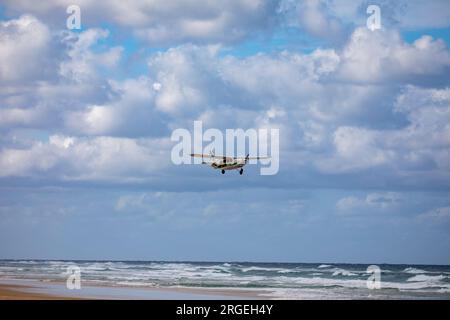 Fraser Island K'gari small aeroplane light aircraft flies over 75 mile beach and the ocean on Fraser Island,Australia Stock Photo