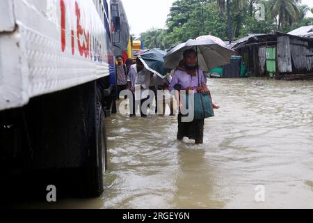 Chattogram. 9th Aug, 2023. Pedestrians wade through a flooded street in Chattogram, Bangladesh, on Aug. 8, 2023. Days of torrential rains have lashed Bangladesh's seaport city Chattogram, some 242 km southeast of capital Dhaka, inundating low-lying areas and disrupting road traffic with the highest downpour so far this year recorded on Monday.Roads, lanes and bylanes in parts of the country's premier seaport city went under ankle to knee-deep water, causing immense hardship to commuters and its millions of dwellers. Credit: Xinhua/Alamy Live News Stock Photo