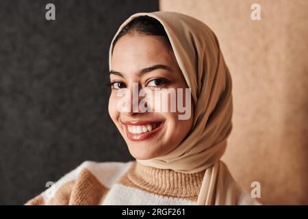 Close up portrait of smiling Middle Eastern woman wearing headscarf and looking at camera with confidence Stock Photo