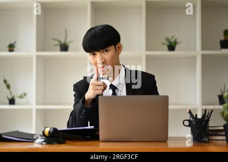 Handsome male lawyer sitting in his personal office and looking confidently to camera Stock Photo