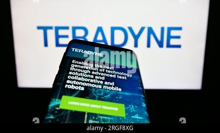 Smartphone with website of US test equipment company Teradyne Inc. on screen in front of business logo. Focus on top-left of phone display. Stock Photo