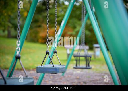A Close up of empty swing set in public park Stock Photo