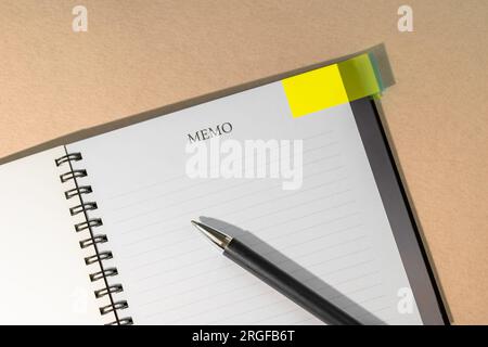 Notebook with yellow page marker note and pen on table. Blank pages for copy space. Reminder concept Stock Photo