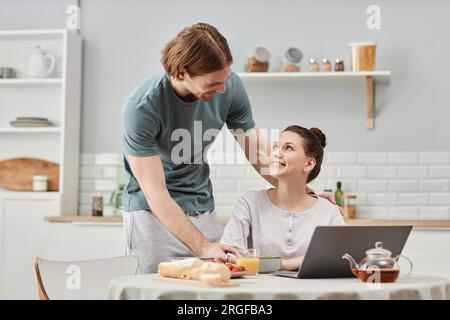 Portrait of affectionate young couple enjoying breakfast in morning together and looking at each other Stock Photo