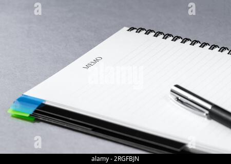 Opened spiral notebook with page markers and black pen, black metal spiral. Space to add text Stock Photo