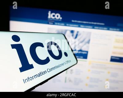Mobile phone with logo of British Information Commissioner's Office (ICO) on screen in front of website. Focus on left of phone display. Stock Photo