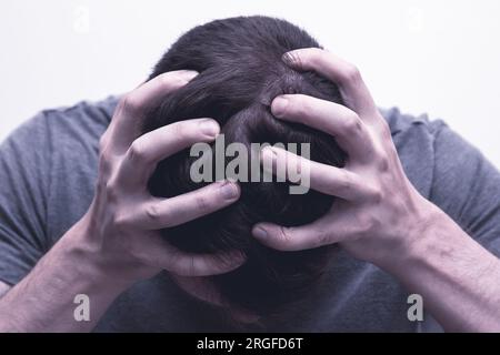 Man holding his head for having breakdown or panic attack Stock Photo