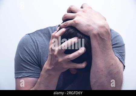 Man holding his head for having breakdown or panic attack Stock Photo