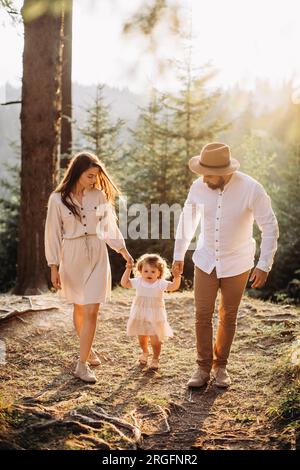 Young happy family chilling in sunny mountains Stock Photo