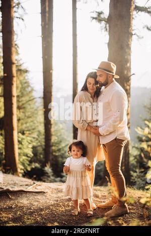 Young happy family chilling in sunny mountains Stock Photo