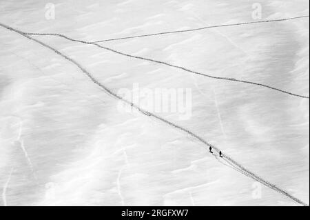 Two climbers walking on Géant glacier near Aiguille du Midi in Mont Blanc massif in black and white Stock Photo