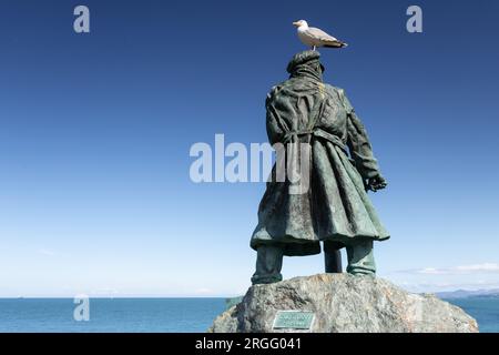 Bronze statue of Dic Evans at Moelfre, Anglesey, North Wales, with seagull Stock Photo