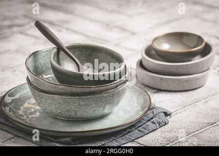 Gray stoneware plates and bowls on a rustic table, copy space Stock Photo