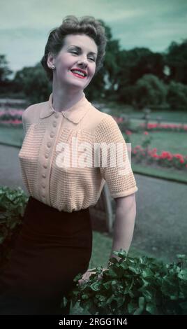 https://l450v.alamy.com/450v/2rgg1n4/1950s-historical-fashionan-elegant-attractive-lady-standing-outside-wearing-a-short-sleeve-ribbed-pink-woollen-collar-or-polo-top-reflecting-her-feminine-delicate-features-and-refined-sophisticated-style-england-uk-stylist-woollen-tops-and-sweaters-worn-over-a-cone-or-bullet-shaped-bra-as-seen-here-were-a-popular-clothing-item-in-this-era-as-new-yarns-and-colours-were-introduced-2rgg1n4.jpg