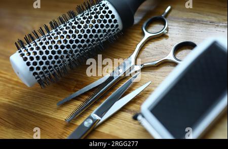 Clipper and comb lie on wooden table in hairdresser closeup Stock Photo