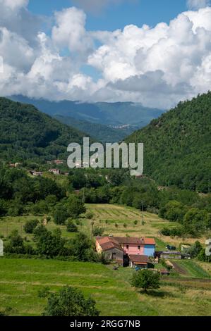 Surrounded by steep wooded mountain slopes and on the valley floor of Valle Ombrosa  (Shady Valley) with olive groves and farming is the hamlet of Pos Stock Photo