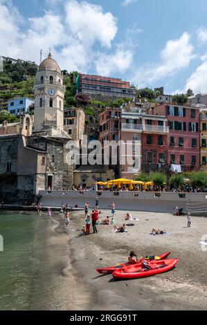 A small harbour and a small Piazza (Square) filled with a mix of eateries, ice cream parlours and the prominent Santa Margherita di Antiochia Church a Stock Photo