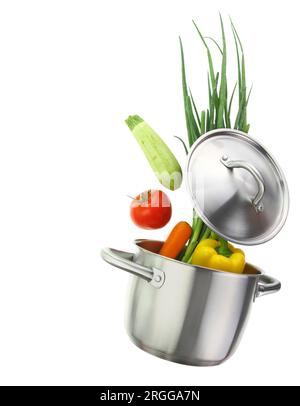 Fresh vegetables falling into a cooking pot isolated on white transparent background Stock Photo