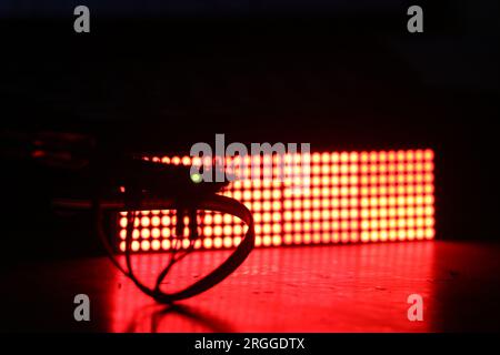 Microcontroller is controlling an electronic component on the background. LED dot matrix display board illuminating red color light Stock Photo