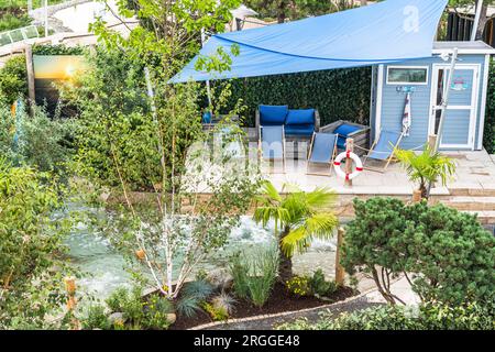 Top view of a terrace with sun loungers by a modern built-in swimming pool. Bubbling swimming pool, spa area Stock Photo