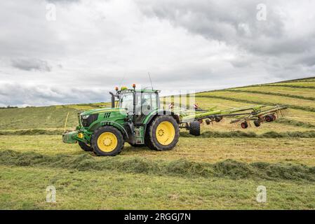 Tractor rowing up during silage making at Little Newton Long Preston, near Hellifield, Yorkshire Dales during a brief weather window, Stock Photo