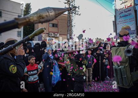Gaza, Gaza, Palestine. 9th Aug, 2023. A Palestinian woman scatters flowers on members of the Jerusalem Brigades during their march (Credit Image: © Saher Alghorra/ZUMA Press Wire) EDITORIAL USAGE ONLY! Not for Commercial USAGE! Stock Photo