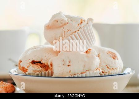 closeup of a white ceramic bowl with some merengues almendrados, baked meringues with almonds, typical of spain Stock Photo