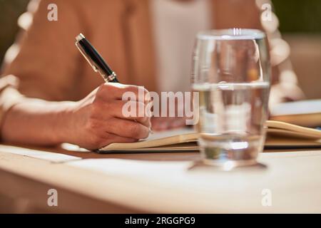Hand of businesswoman writing notes Stock Photo