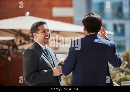 Businessmen talking at cafe Stock Photo