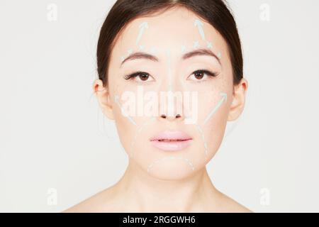 Young woman with lines drawn on face Stock Photo