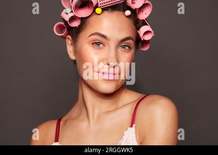 Portrait of young woman wearing hair rollers Stock Photo