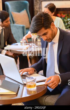Businessman working on laptop at bar Stock Photo