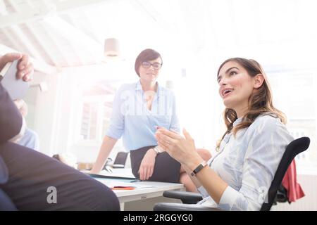 Young businesswoman talking to colleagues in office Stock Photo