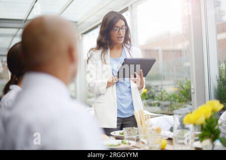 Businesswoman giving speech with tablet PC Stock Photo
