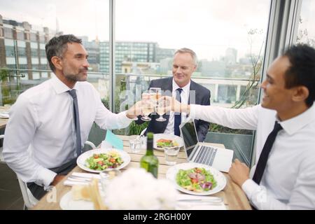Businessmen toasting during meeting at restaurant Stock Photo