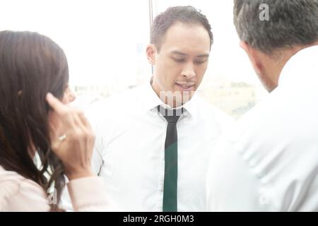 Businesspeople talking by window Stock Photo