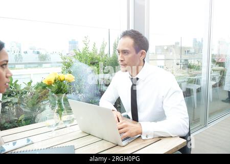 Businesspeople using laptop during restaurant meeting Stock Photo
