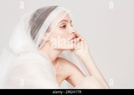Young woman wrapped in sheer sheet Stock Photo