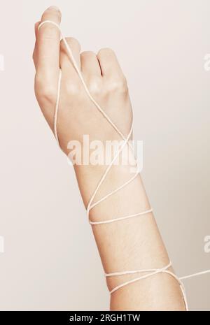 Woman's hand wrapped in string Stock Photo