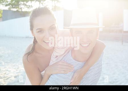 Young man giving girlfriend piggyback in Ko Samui, Thailand Stock Photo