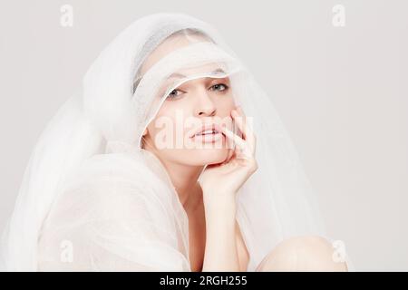 Young woman wrapped in sheer sheet Stock Photo