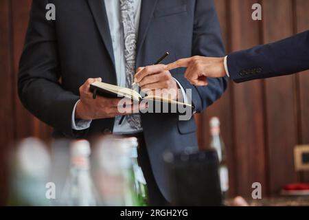 Businessman taking notes during meeting Stock Photo